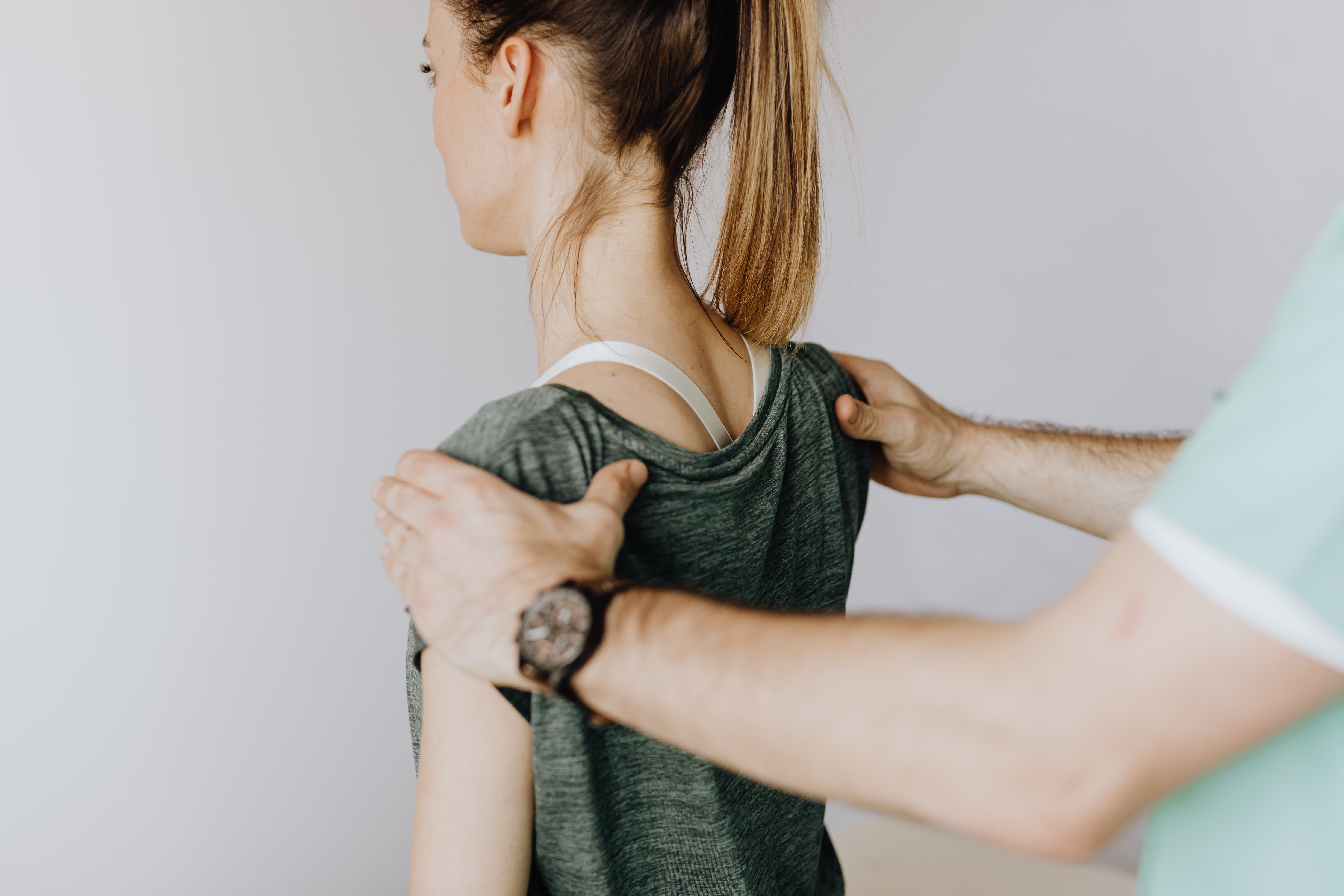 fisioterapista che effettua un massaggio per sciogliere una contrattura muscolare alla schiena