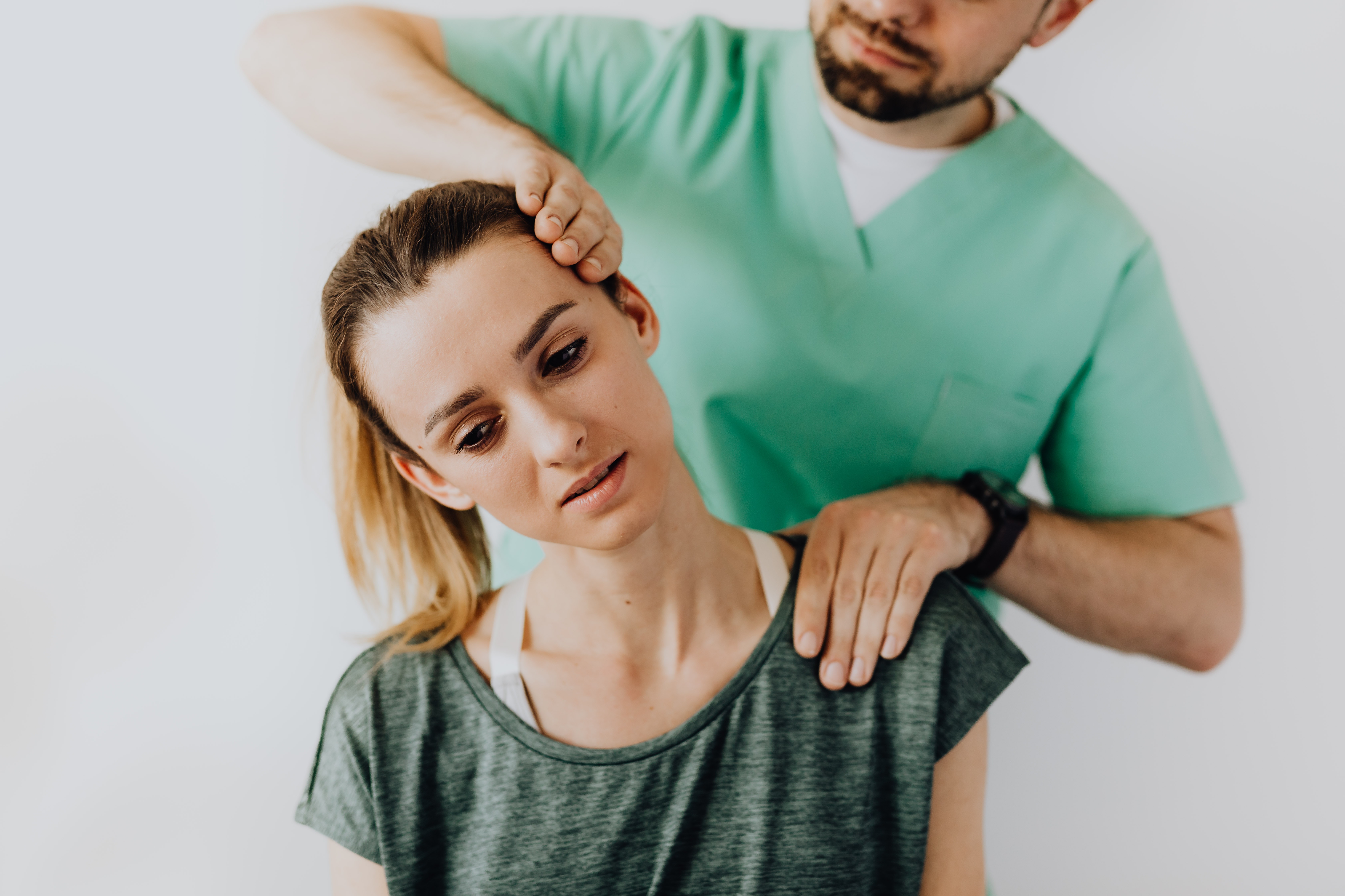dolore cervicale - Fisioterapista pratica massaggio al collo di una ragazza